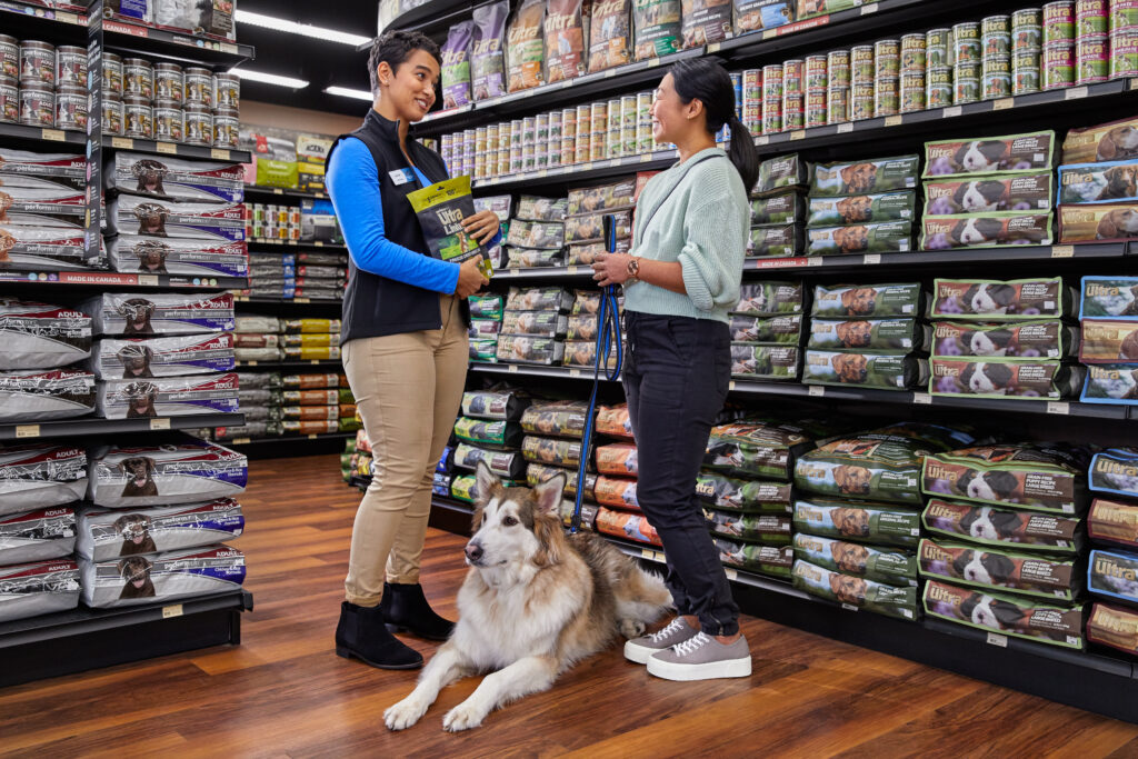 A Pet Valu franchisee assists a customer and their dog.