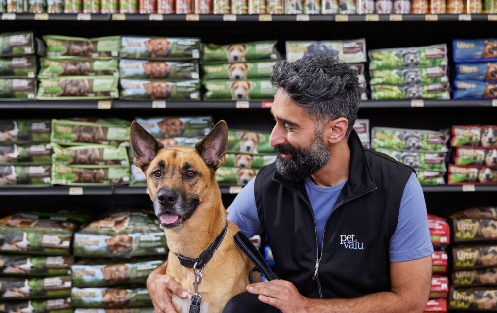 A Pet Valu franchisee smiles at a dog.
