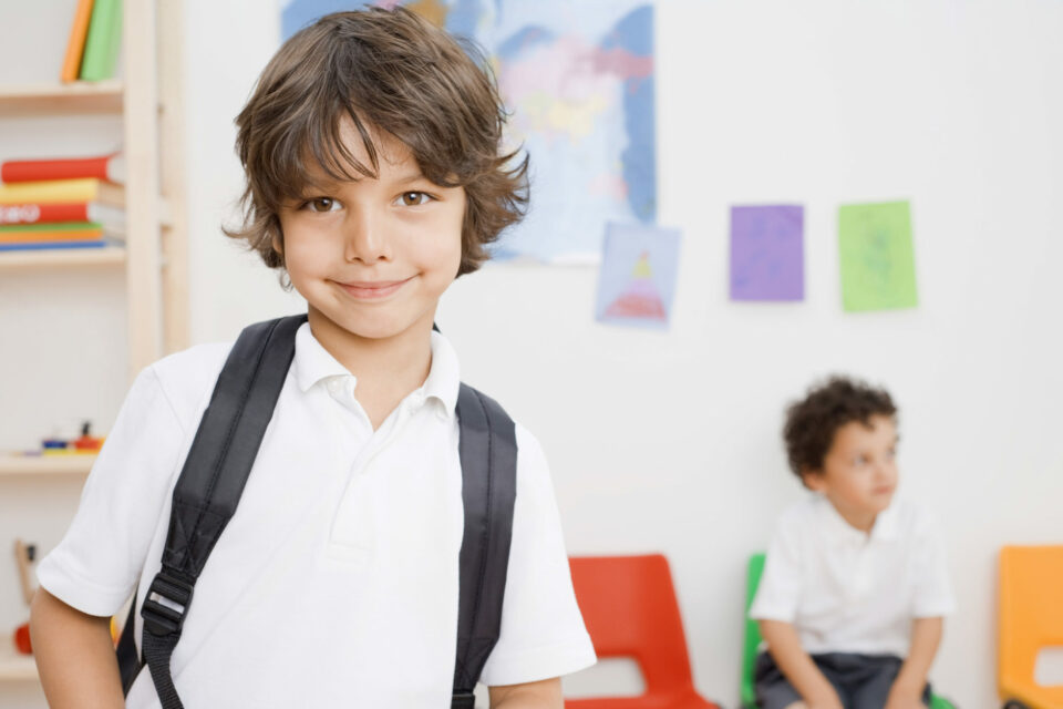 Reach LEarning Centre franchise image of a child smiling wearing a white button-down shirt.