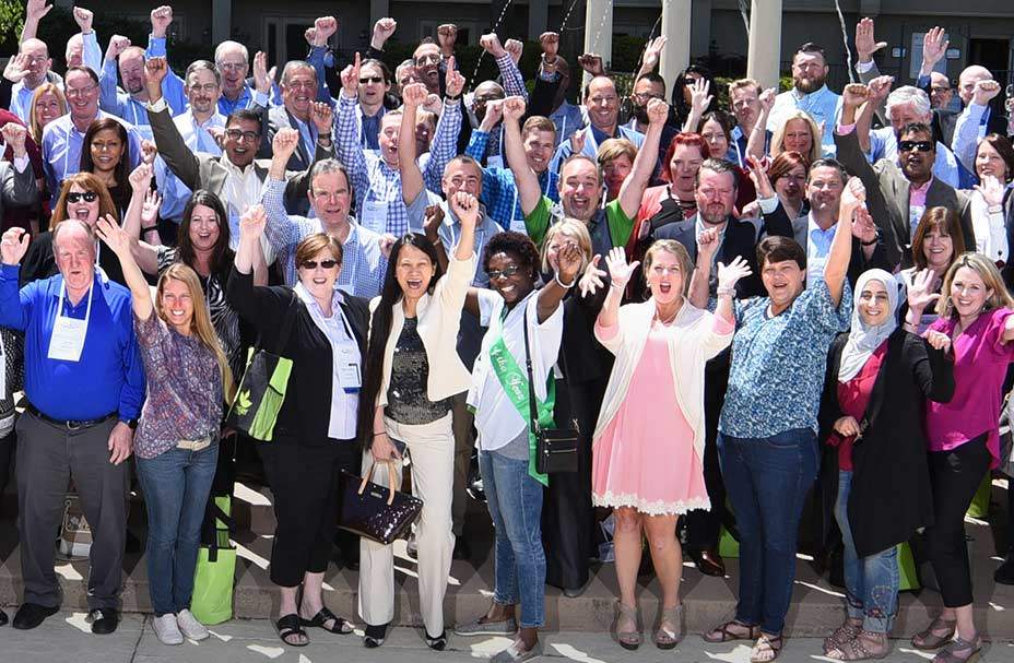 FirstLight Home Care staff stand with fists raised for a group photo